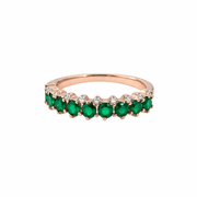 Elegant rose gold ring with vibrant green stones and sparkling accents.