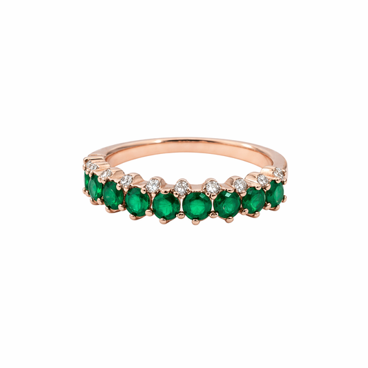 Elegant rose gold ring with vibrant green stones and sparkling accents.