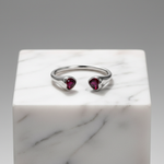 Elegant open-ended silver ring featuring twin heart-shaped ruby stones.