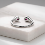 Elegant open-ended silver ring featuring twin heart-shaped ruby stones.