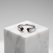 Elegant open-ended silver ring featuring twin heart-shaped ruby stones.